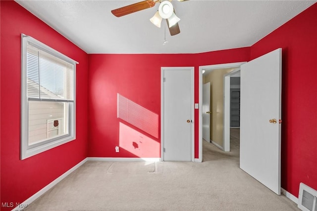 unfurnished room with ceiling fan and light colored carpet