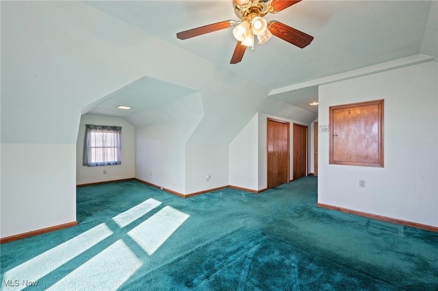 additional living space with ceiling fan, lofted ceiling, and dark colored carpet