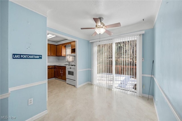 kitchen with white range with gas cooktop, sink, a healthy amount of sunlight, and ceiling fan