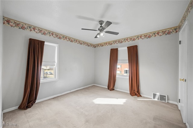 unfurnished room with ceiling fan and light carpet