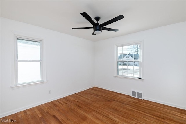 empty room with hardwood / wood-style floors and ceiling fan