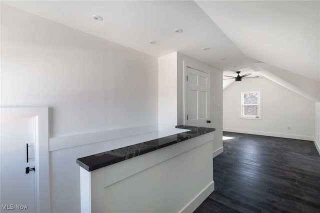 interior space featuring vaulted ceiling, dark hardwood / wood-style floors, and ceiling fan