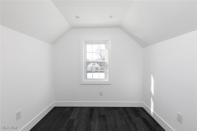 additional living space with dark wood-type flooring and lofted ceiling