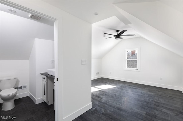 additional living space featuring vaulted ceiling, dark wood-type flooring, and ceiling fan