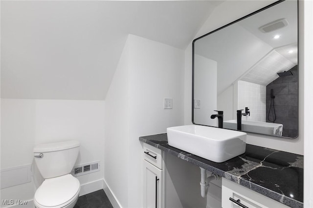 bathroom featuring walk in shower, lofted ceiling, vanity, and toilet