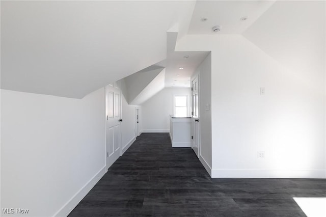 bonus room with lofted ceiling and dark hardwood / wood-style flooring