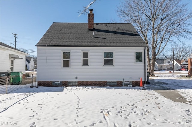 view of snow covered back of property