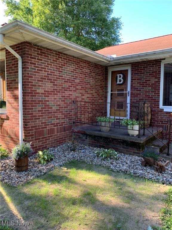 property entrance featuring a lawn