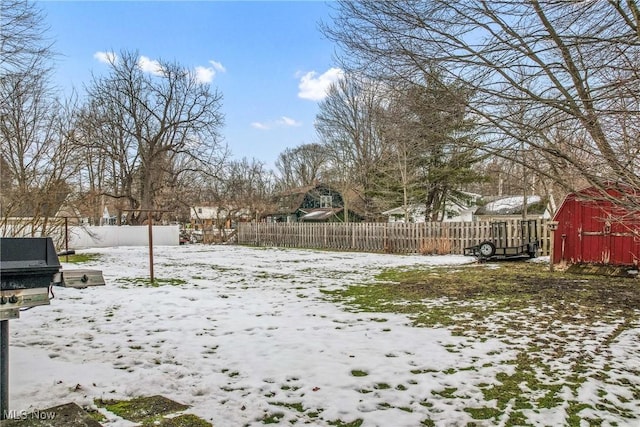 yard covered in snow with a shed