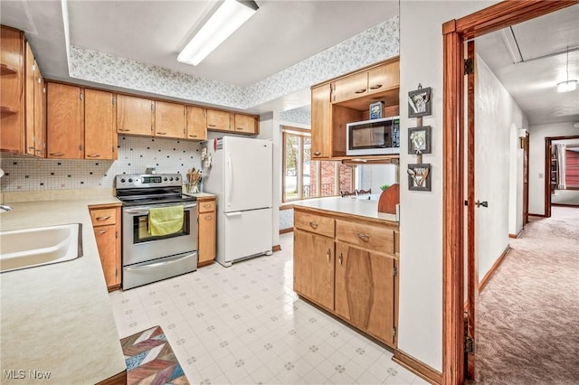 kitchen featuring appliances with stainless steel finishes, sink, and decorative backsplash