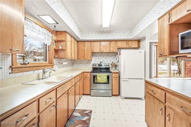 kitchen featuring sink, white refrigerator, a healthy amount of sunlight, and stainless steel electric range oven