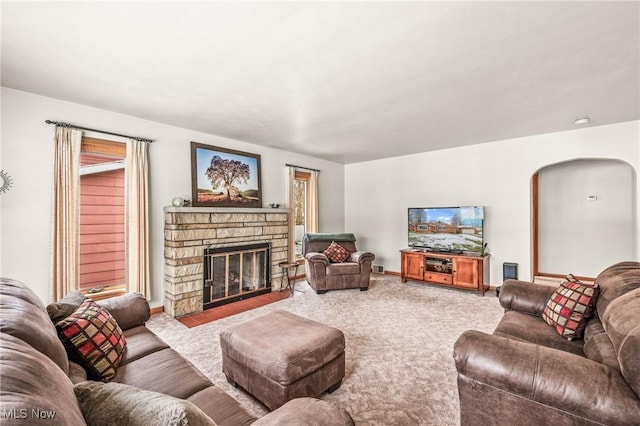 carpeted living room featuring a fireplace and a healthy amount of sunlight