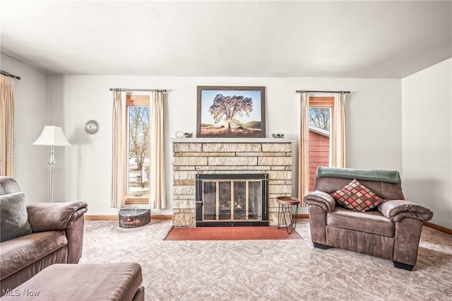 living room with a stone fireplace and carpet