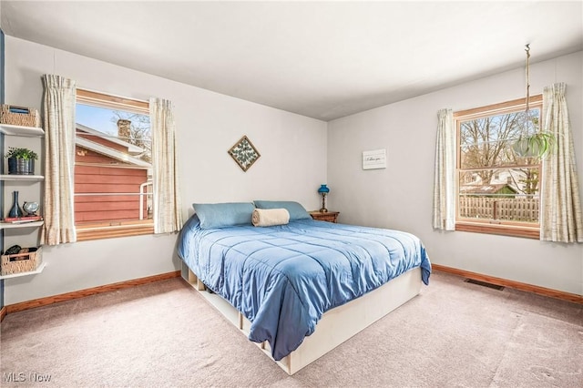 carpeted bedroom featuring multiple windows