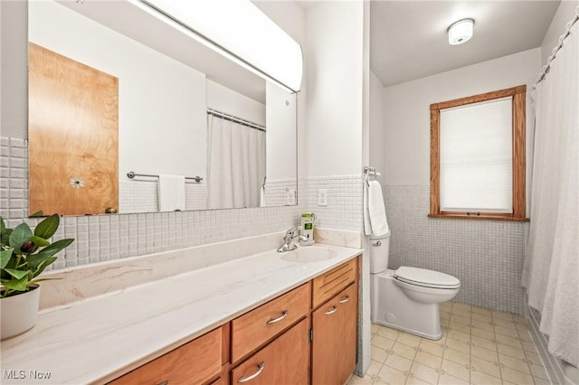 bathroom featuring vanity, tile walls, and toilet