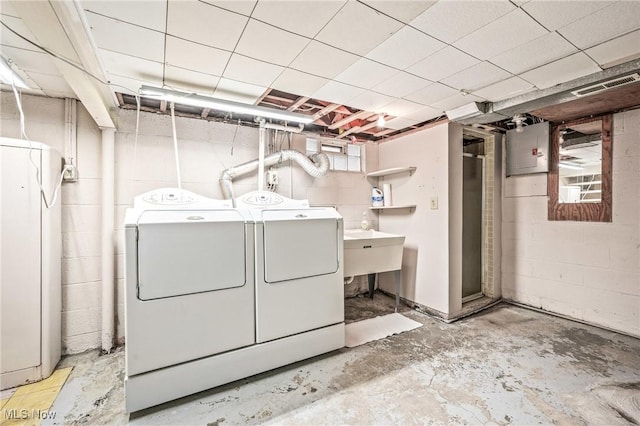 laundry room featuring electric panel and washing machine and clothes dryer