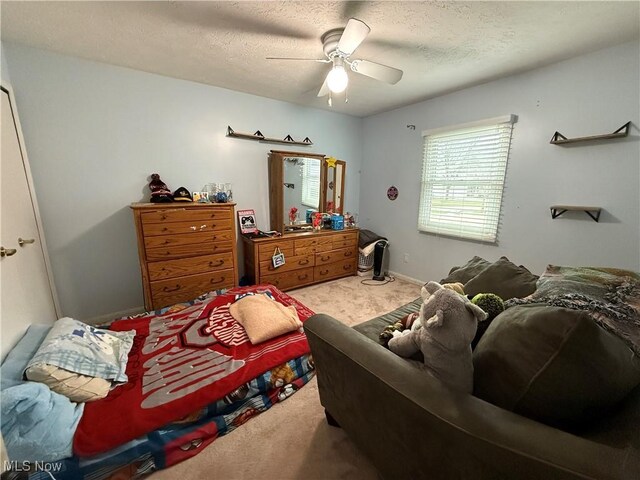 carpeted bedroom featuring ceiling fan and a textured ceiling