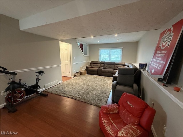 living room with wood-type flooring and a textured ceiling