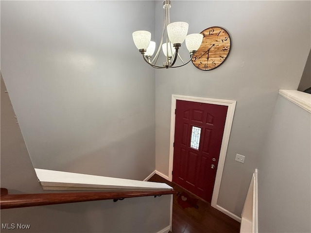 entryway with a notable chandelier and dark wood-type flooring