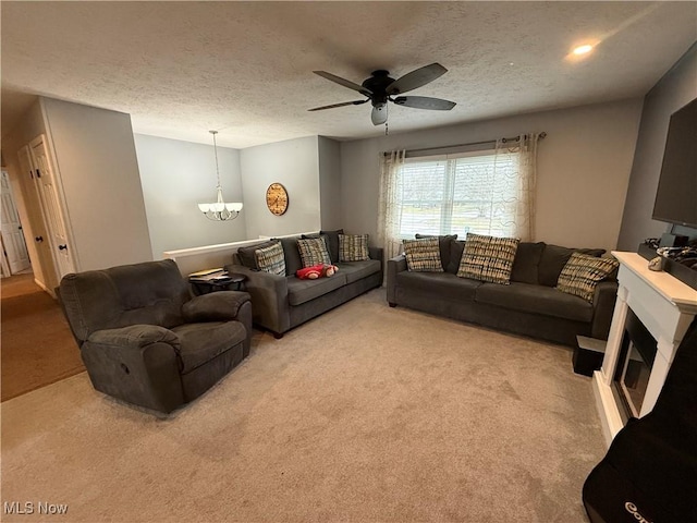 living room featuring light colored carpet, ceiling fan with notable chandelier, and a textured ceiling