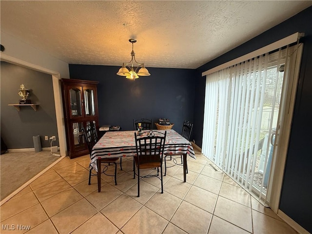 dining space with light tile patterned flooring, a chandelier, and a textured ceiling