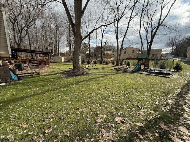 view of yard with a storage shed, central AC unit, and a playground