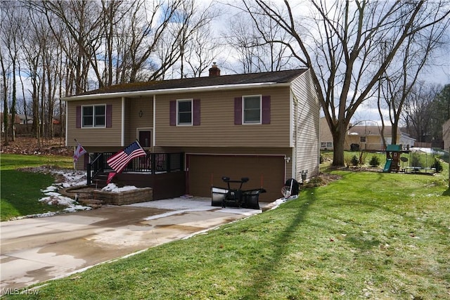 bi-level home featuring a garage, a front yard, and a playground