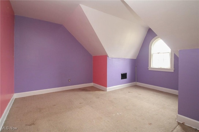 additional living space with light colored carpet and lofted ceiling