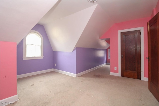 additional living space with light colored carpet and lofted ceiling