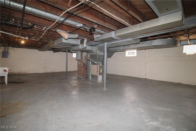 basement featuring heating unit and electric panel