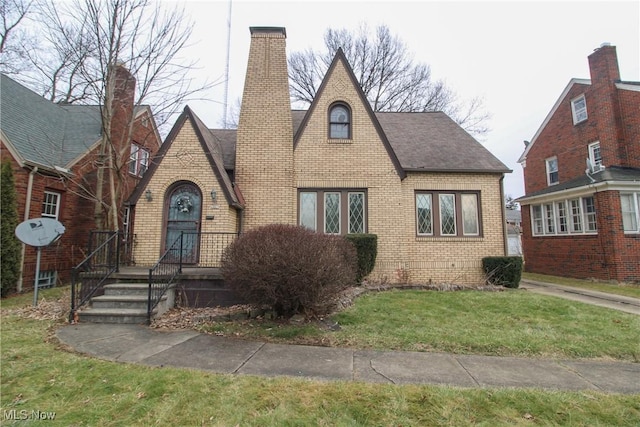 tudor-style house featuring a front lawn