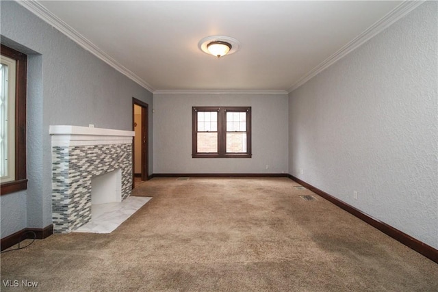 carpeted spare room with a tiled fireplace and crown molding