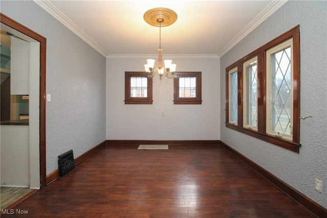 spare room with dark hardwood / wood-style flooring, crown molding, and an inviting chandelier