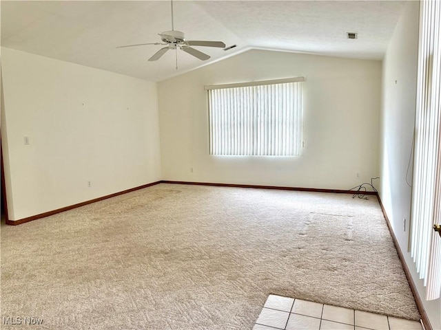 carpeted empty room featuring vaulted ceiling and ceiling fan