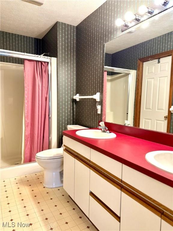 bathroom featuring vanity, a shower with curtain, a textured ceiling, and toilet