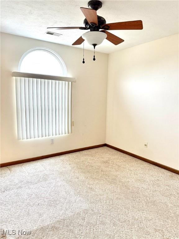 empty room featuring carpet floors and ceiling fan