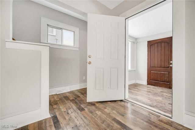 foyer entrance featuring wood finished floors, visible vents, and baseboards