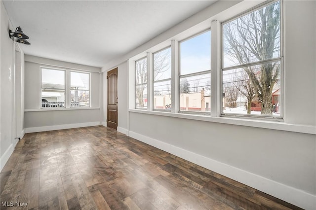 empty room with wood-type flooring and baseboards