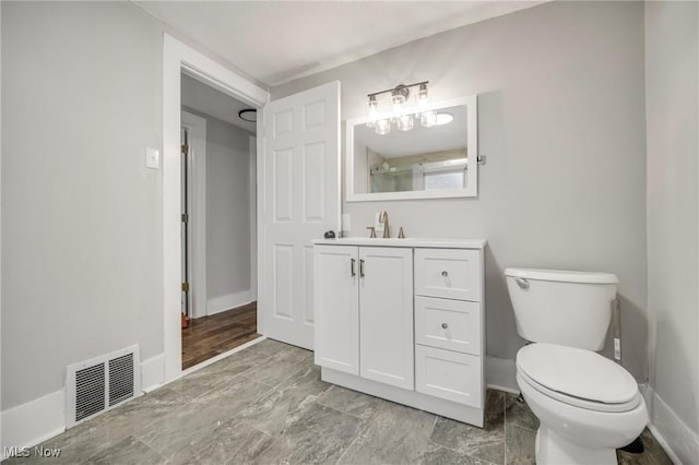 bathroom featuring baseboards, visible vents, vanity, and toilet