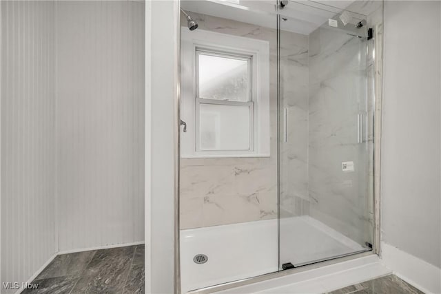 full bathroom with baseboards and a marble finish shower