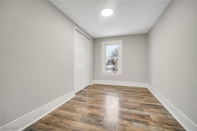 empty room featuring baseboards and wood finished floors