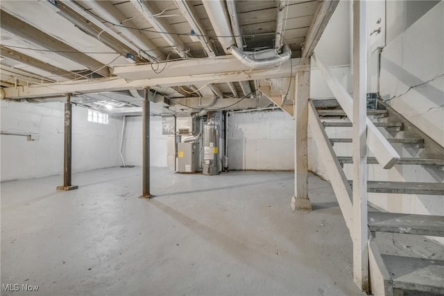 basement featuring water heater, heating unit, and stairs