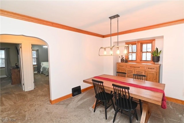 dining area with ornamental molding and carpet flooring