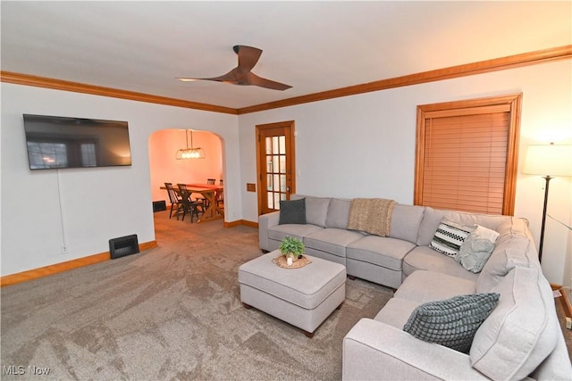 living room with ceiling fan, ornamental molding, and carpet flooring