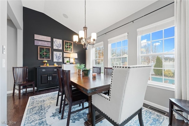 dining room featuring vaulted ceiling, a notable chandelier, and dark hardwood / wood-style flooring