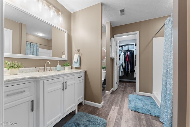 bathroom featuring wood-type flooring, curtained shower, and vanity