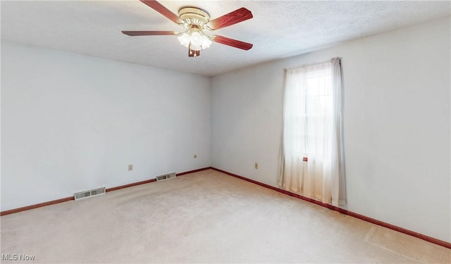 carpeted spare room featuring a textured ceiling and ceiling fan