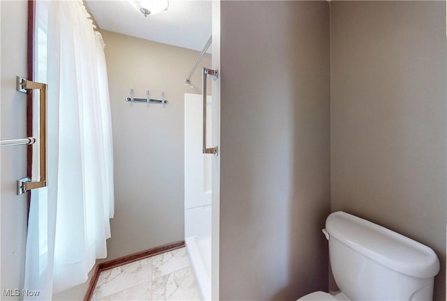 bathroom with curtained shower and toilet