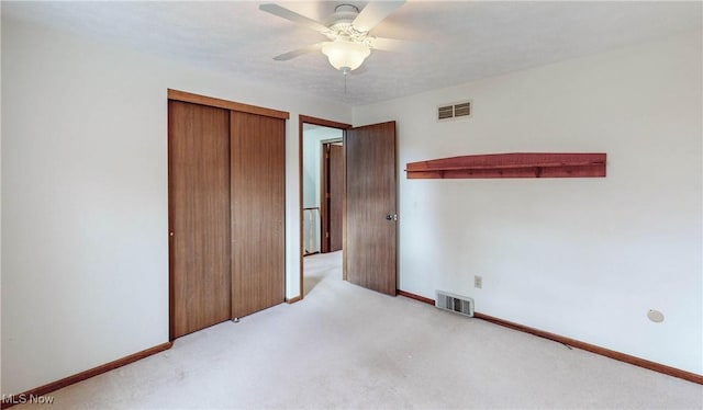 unfurnished bedroom with light colored carpet, a closet, and ceiling fan