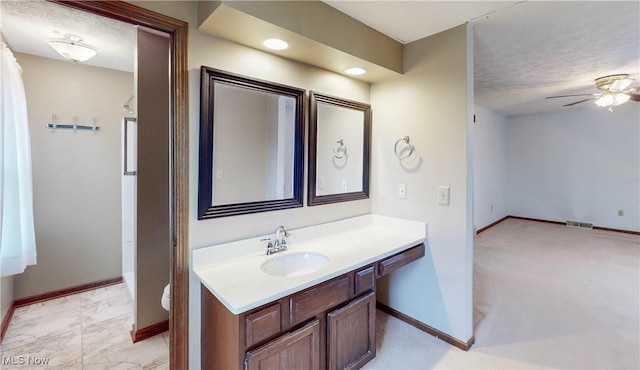 bathroom featuring vanity, a textured ceiling, ceiling fan, and toilet